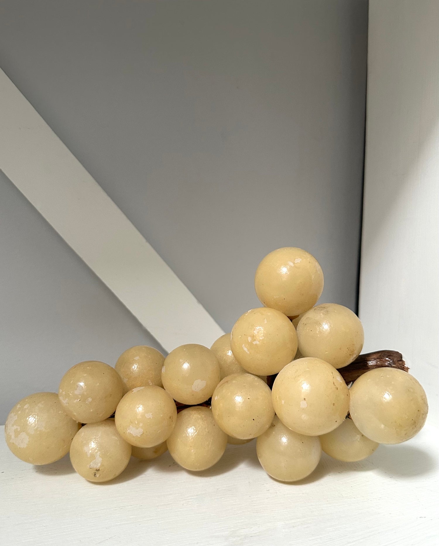 Decorative sculpture resembling a bunch of grapes on a plain background