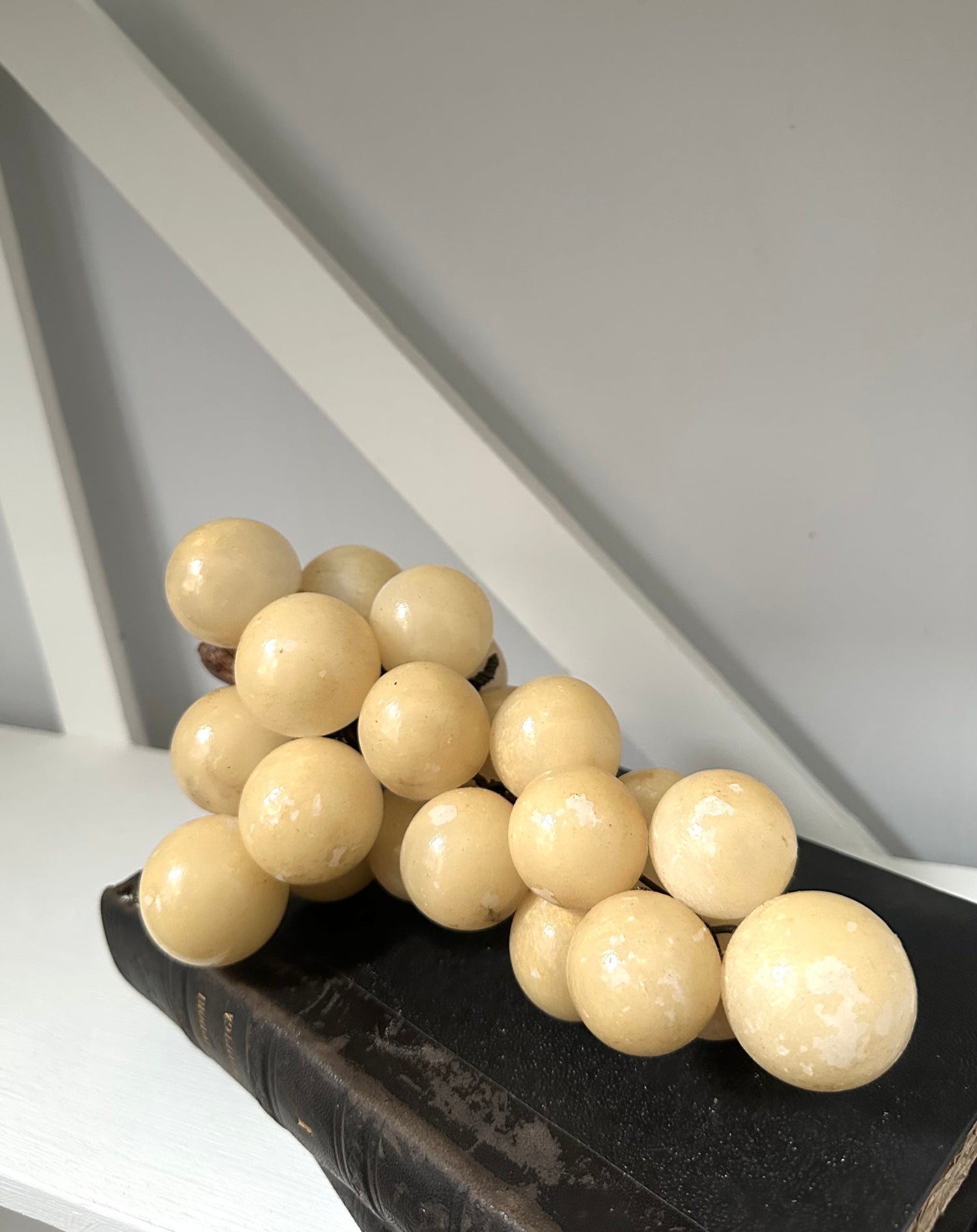 Decorative arrangement of beige spherical objects on a dark surface with a white background