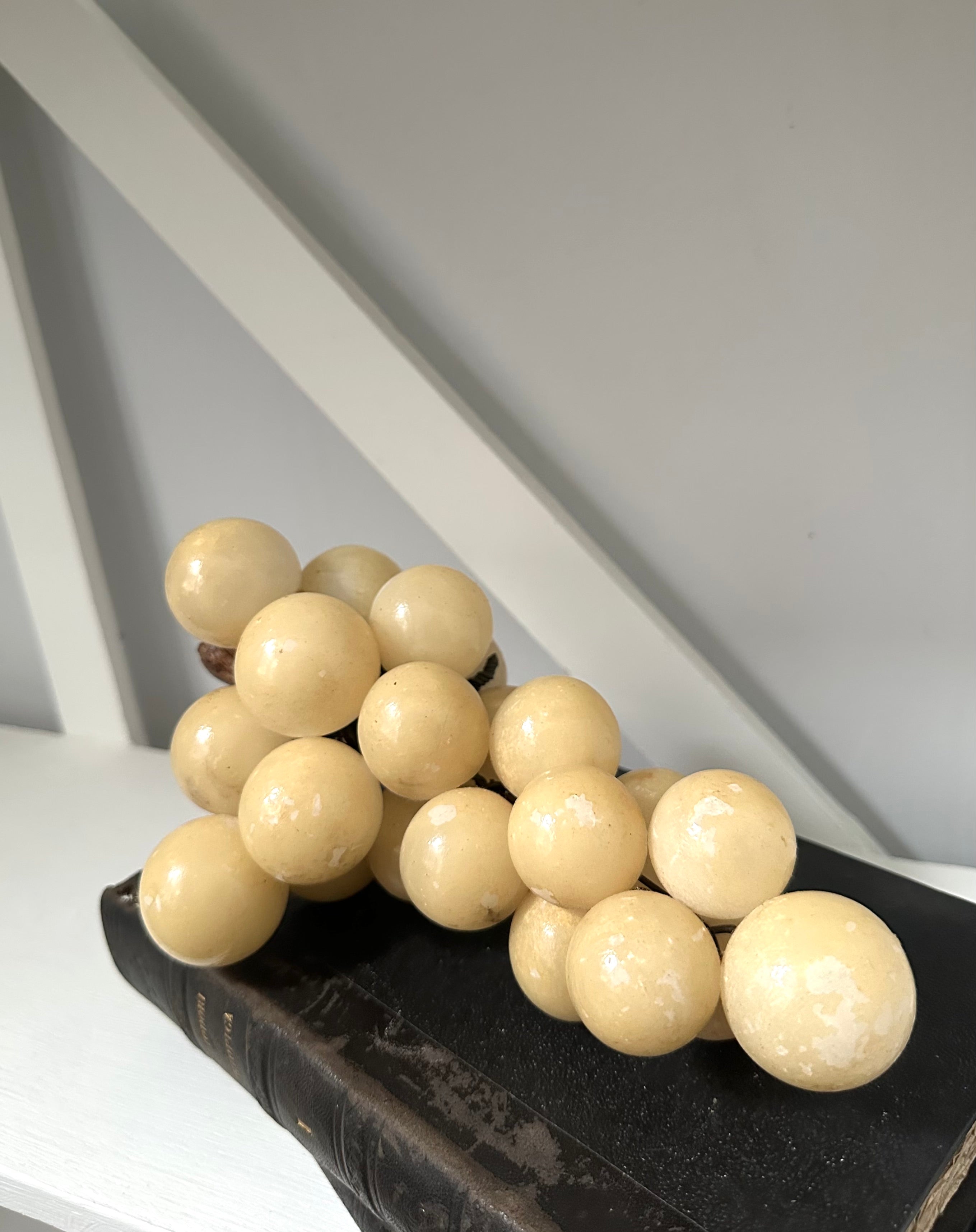 Decorative arrangement of beige spherical objects on a dark surface with a white background