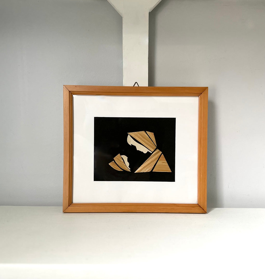 Framed artwork with abstract design on a white wall