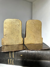 Pair of gold bookends on a black leather-bound book