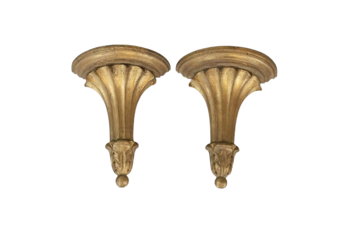 Two decorative wall brackets with a gold finish on a white background