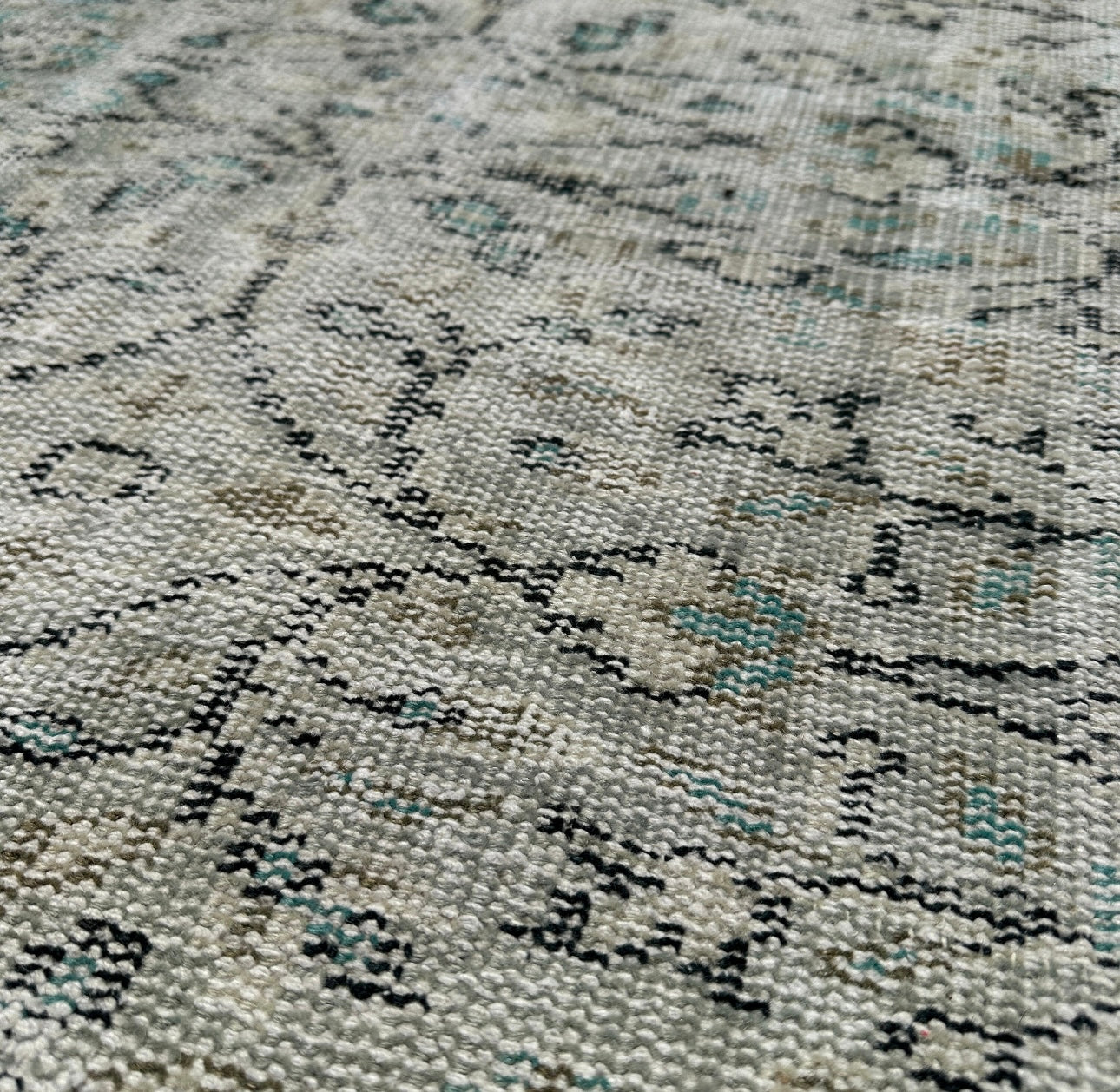 Close-up of a textured rug with a pattern of black and gray.
