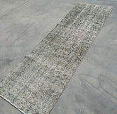 Long rectangular rug with a textured pattern on a concrete floor