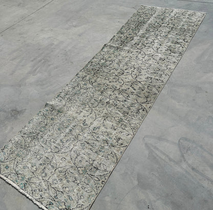 Long rectangular rug with a textured pattern on a concrete floor
