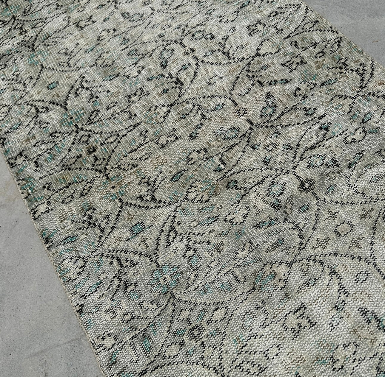 Close-up of a patterned rug on a concrete floor